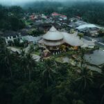 A stunning aerial view of a bamboo resort in Tegallalang, Bali, Indonesia, surrounded by lush greenery.