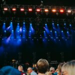 Night concert scene with audience, stage, and colorful lighting effects.