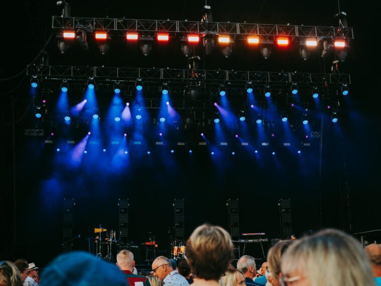 Night concert scene with audience, stage, and colorful lighting effects.