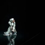 A performer in dramatic stage lighting, showcasing expressive art and emotion.