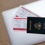 Close-up of a passport and boarding passes on a laptop, symbolizing travel preparation.