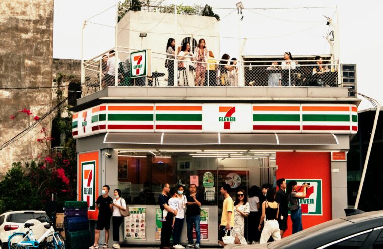 Lively 7-Eleven with rooftop social gathering showcasing modern urban lifestyle in China.