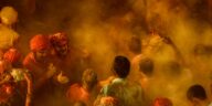 Colorful and energetic Holi celebration with joyful crowd immersed in vibrant powder.
