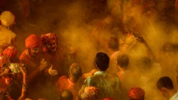 Colorful and energetic Holi celebration with joyful crowd immersed in vibrant powder.