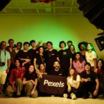 A diverse group of adults posing together in a studio environment during a photoshoot, showcasing camaraderie.