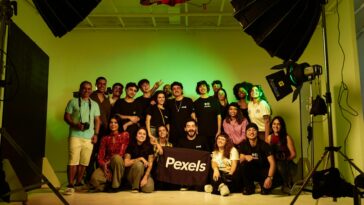 A diverse group of adults posing together in a studio environment during a photoshoot, showcasing camaraderie.