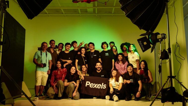 A diverse group of adults posing together in a studio environment during a photoshoot, showcasing camaraderie.