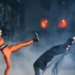 Two cosplayers in a dramatic martial arts duel, showcasing agility and strength.