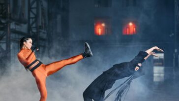 Two cosplayers in a dramatic martial arts duel, showcasing agility and strength.