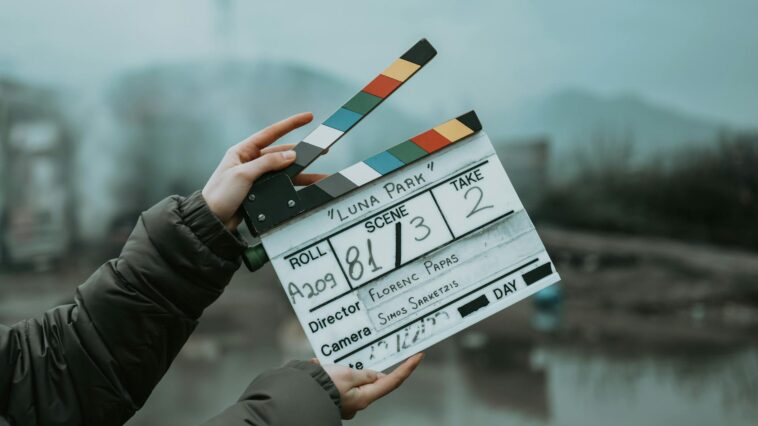 Close-up of a film clapperboard on an outdoor set, signaling scene start.