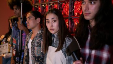 A group of diverse young adults on a film set, engaging in a creative production indoors.