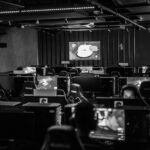 Black and white view of an active esports gaming studio with players immersed in video games.