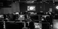 Black and white view of an active esports gaming studio with players immersed in video games.