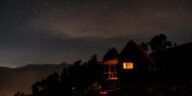 A beautiful silhouette of a cabin under a starry night sky, showcasing the peaceful outdoors.