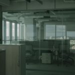 Spacious empty office with glass walls and city views, ideal for modern workspace settings.