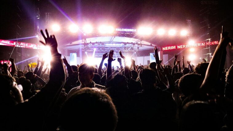 Energetic crowd enjoying a live concert under bright stage lights in Guwahati, India.