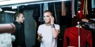 A drag queen applying makeup backstage, showcasing transformation and self-expression.