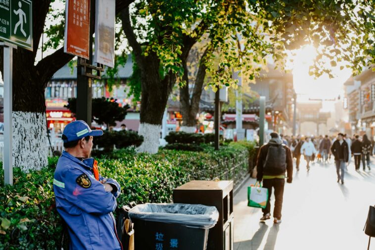 A vibrant street scene in Nanjing, China during fall, showcasing daily urban life.