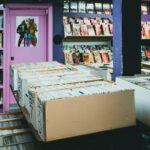 A colorful comic book store with organized shelves and boxes of comics for sale.