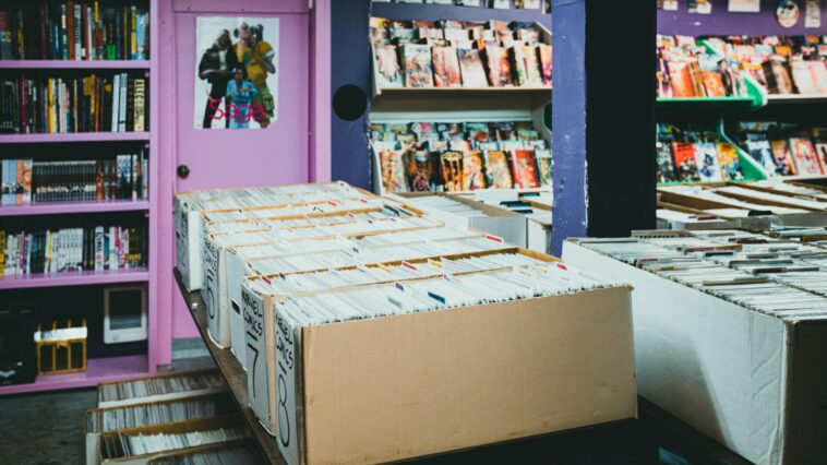 A colorful comic book store with organized shelves and boxes of comics for sale.