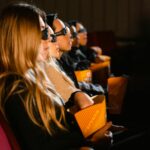 Group of people wearing 3D glasses watching a movie in a cinema, captivated by the film.