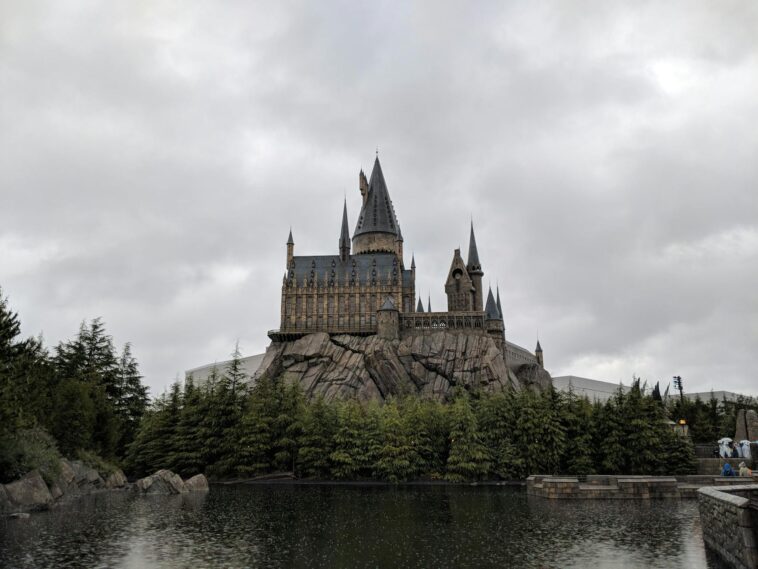 Majestic exterior view of Hogwarts Castle at Universal Studios Japan with a scenic water reflection.