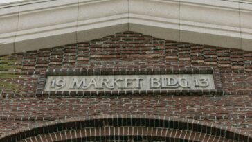 Architectural detail of a historic brick building facade with a market sign.