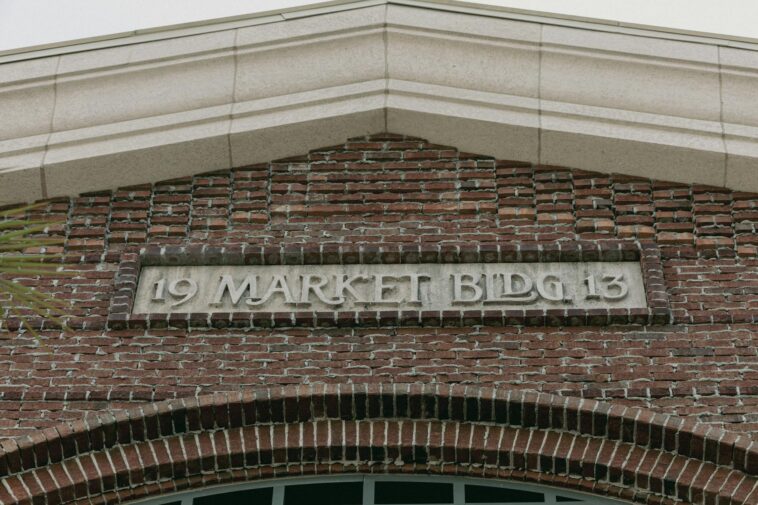 Architectural detail of a historic brick building facade with a market sign.