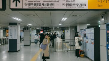 Busy day at a Seoul subway station with commuters navigating their way.