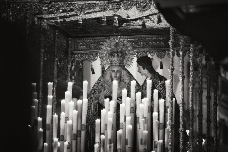 Black and white image of a religious altar with statues and candles in Carmona, Spain.