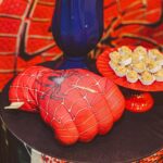 Vibrant Spider-Man themed glove and desserts on a decorative tray for a lively food presentation.