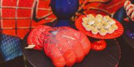 Vibrant Spider-Man themed glove and desserts on a decorative tray for a lively food presentation.