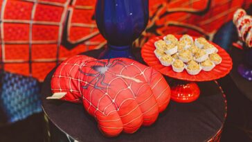 Vibrant Spider-Man themed glove and desserts on a decorative tray for a lively food presentation.