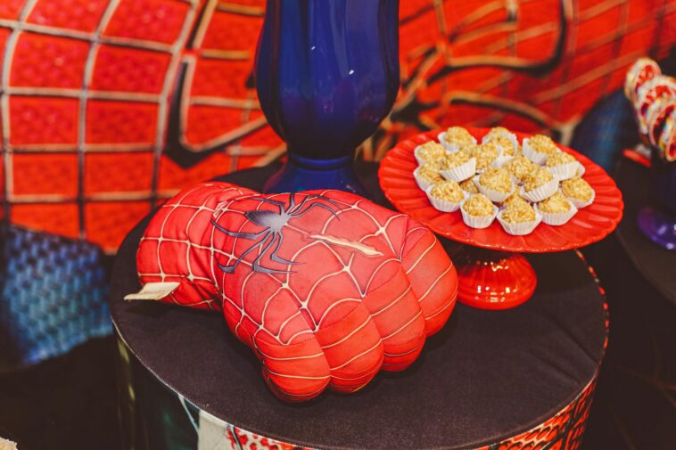 Vibrant Spider-Man themed glove and desserts on a decorative tray for a lively food presentation.