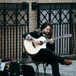 Street performer with a 12-string guitar in Dublin's urban setting.