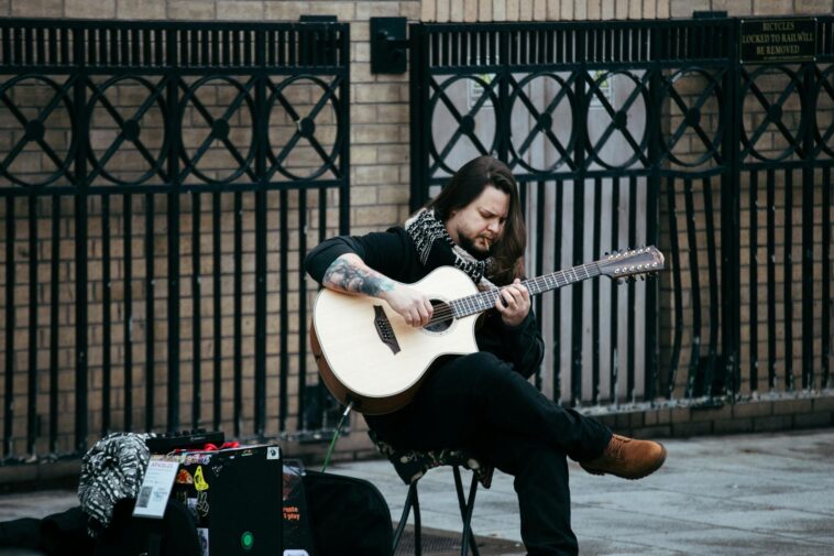 Street performer with a 12-string guitar in Dublin's urban setting.
