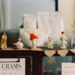 A cozy display of handcrafted figurines on a café shelf with vintage charm.