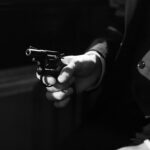 Black and white image capturing a suspenseful noir scene with a handgun.