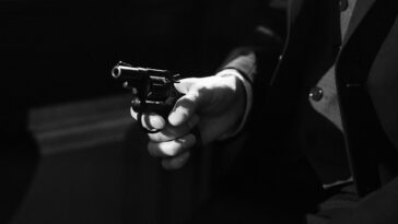 Black and white image capturing a suspenseful noir scene with a handgun.