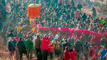 A vibrant traditional festival featuring a lively dragon dance procession outdoors.