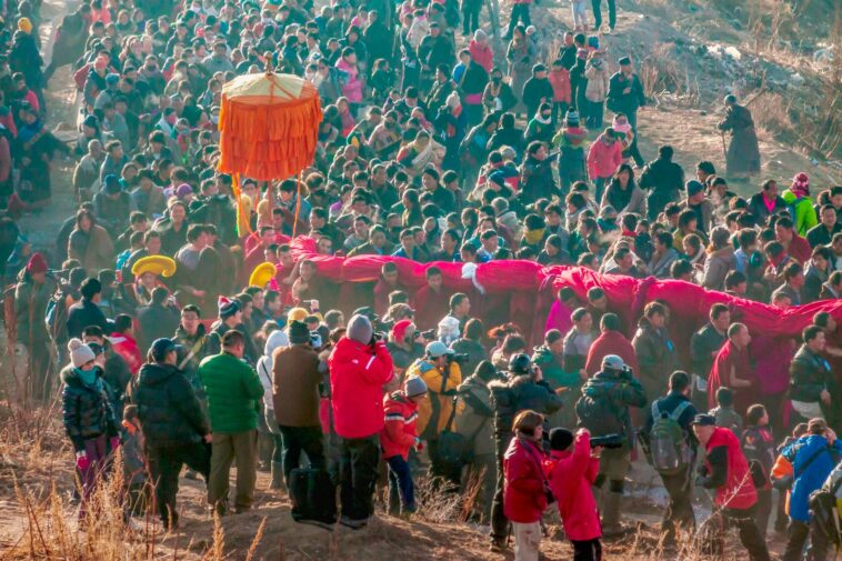 A vibrant traditional festival featuring a lively dragon dance procession outdoors.