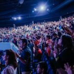 Energetic crowd at a music concert inside a large arena. Perfect capture of audience excitement.