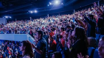 Energetic crowd at a music concert inside a large arena. Perfect capture of audience excitement.