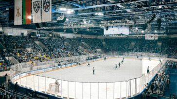Exciting ice hockey game with players and crowd in a vibrant indoor arena atmosphere.