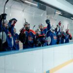 Youth hockey players celebrating in the ice arena, showing team spirit and unity.