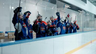 Youth hockey players celebrating in the ice arena, showing team spirit and unity.