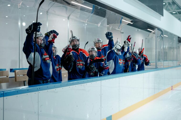 Youth hockey players celebrating in the ice arena, showing team spirit and unity.