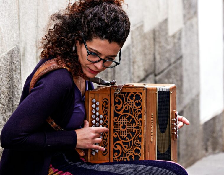 Woman playing accordion on a stone street in Porto, Portugal. Captivating street performance.