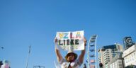 A person holds a sign reading 'VZLA Libre 2026' in a peaceful protest with a city backdrop.