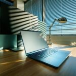 A clean, sunlit office desk with a modern laptop and monitor, perfect for business or corporate settings.